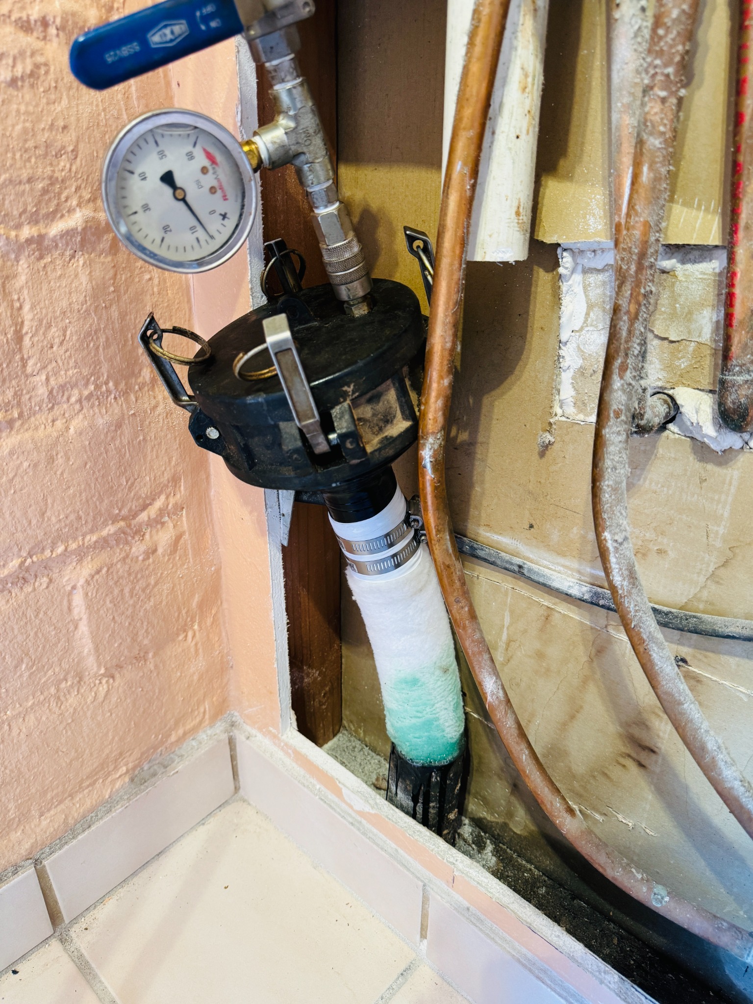 Pressure-monitored trenchless liner installation through a residential wall access